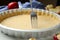 Making holes in raw dough for traditional English apple pie with fork on white table, closeup