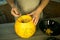 Making Jack O`Lantern at home. Pumpkin preparation process. Women`s hands take out seeds from a pumpkin