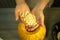 Making Jack O`Lantern at home. Pumpkin preparation process. Women`s hands take out seeds from a pumpkin