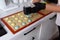 Making macaroons.The dough from the syringe is squeezed out on a baking sheet.