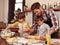 Making mom some mothers day cookies. Two cute little boys baking with their father in the kitchen.