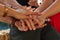 Making a pact to stay friends forever. a group of unidentifiable friends putting their hands in a pile at an outdoor