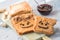 Making peanut butter sandwiches with personality! Fun smiley face drawn on with jam. Creamy peanut butter with jam on whole grain