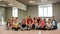 Making a photo. Group of positive little boys and girls in fashionable clothes posing with their young female teacher in