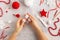 Making pom-poms from red and white threads. Ideas of Christmas decoration diy with kids