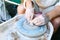 Making pottery on a potter`s wheel. Hands craftsman close-up, mold dishes. Master class