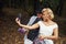 Making a selfie. Beautiful couple in old fashioned wear near retro car with forest at background