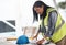 Making some minor adjustments. Cropped shot of an attractive young female construction worker looking over plans on site