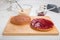 Making sponge cakes, cake spread with jam/preserve on a wooden board