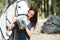 Making sure the bridle is firmly attached. An attractive woman securing her horses bridle outside.