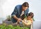 Making sure every plant gets enough water. a father and son tending to the plants in their herb garden.