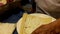 Making tamales. An elderly Mexican woman spreads masa on a corn husk.