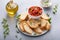 Making tomato basil bruschetta with toasted baguette and herbs