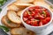 Making tomato basil bruschetta with toasted baguette and herbs