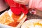 Making Tomato Sauce on the Stove. A close up of the hand mill griinding up the fresh field tomatoes to make tomato sauce