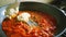 Making tomato and sour cream sauce on a frying pan