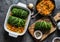 Making vegetarian delicious lunch - roasted savoy cabbage stuffed spicy bulgur. Savoy cabbage bulgur rolls in baking pan on a dark