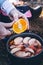 Making a warm mulled wine drink on a hike. Close up of hands cut ingredient orange and add to bowl.