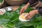 Making wrapping Chung Cake, the Vietnamese lunar new year Tet food outdoor with old woman hands and ingredients. Closed-up.