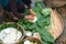 Making wrapping Chung Cake, the Vietnamese lunar new year Tet food outdoor with old woman hands and ingredients. Closed-up.