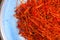 Makro closeup of isolated red dried saffron threads on blue plate