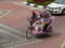 Malacca, Malaysia--February 2018: Wide view of a trishaw with a couple of passengers along the brick-paved Dutch Square in Melaka