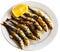 Malaga cuisine grilled sardines served with lemon on white plate on wooden table