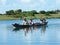 Malagasy family crossing river by canoe