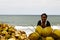 Malagasy woman selling coconuts on the beach