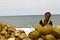 Malagasy woman selling coconuts on the beach