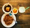 Malay mee tauhu set meal with ice water on wooden table