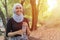 Malay Muslim lady wearing hijab outdoor resting and drink water