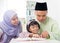 Malay Muslim parents teaching child