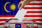 Malaysia flag, hand dropping ballot card into a box - voting, election concept