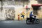 MALAYSIA, PENANG, GEORGETOWN - CIRCA JUL 2014: Man on a motorcycle, passing two diverse murals painted on the same wall.