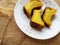 A Malaysia traditional dessert and locally know as KUIH BINGKA UBI KAYU or BAKED CASSAVA served on plate with selective focus.