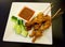 Malaysian chicken satay with peanut sauce and slices of cucumber