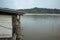 A Malaysian house on stilts sitting on top of a body of water. It is built with planks and zinc roof