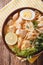 Malaysian laksa soup with chicken close up in a bowl. Vertical t