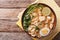 Malaysian laksa soup with chicken, egg, noodles and herbs close