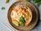 Malaysian noodles laksa soup with chicken, prawn and tofu in a bowl on grey background