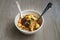 Malaysian noodles laksa soup with chicken, prawn and tofu in a bowl on wooden background