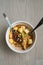 Malaysian noodles laksa soup with chicken, prawn and tofu in a bowl on wooden background