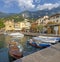 MALCESINE, ITALY - JUNE 13, 2019: The little harbor on the waterfront of Lago di Garda lake with the 2000 m high mountains in the