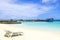 Maldives, beach with chair and dock with boat