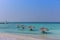 Maldives, Feb 3rd 2018 - Beach umbrellas at the shallow blue water with some divers enjoying the tropical weather of Maldives