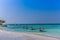 Maldives, Feb 3rd 2018 - Beach umbrellas at the shallow blue water with some divers enjoying the tropical weather of Maldives