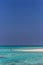 Maldives, Feb 8th 2018 - Tourists swimming in a turquoise blue sea, desert island, small traditional hut hotel on a blue sky day,