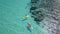 Maldives island. Aerial view of adventurous couple ocean kayaking together in pristine blue lagoon with sunny light