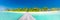 Maldives island beach panorama. Palm trees and beach bar and long wooden pier pathway. Tropical vacation and summer holiday banner